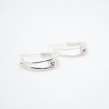 Two silver rings with purple gemstones on a white background