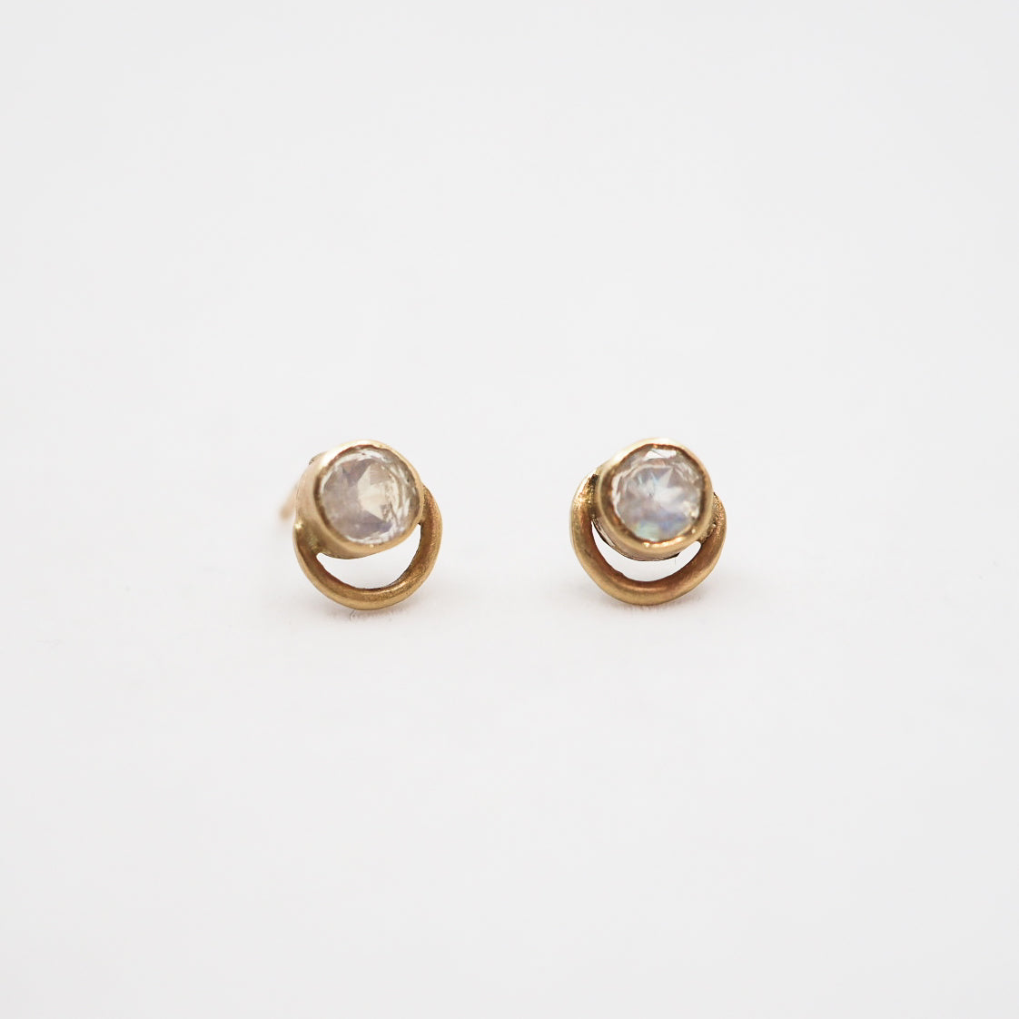 Pair of gold earrings with gemstones on a white background