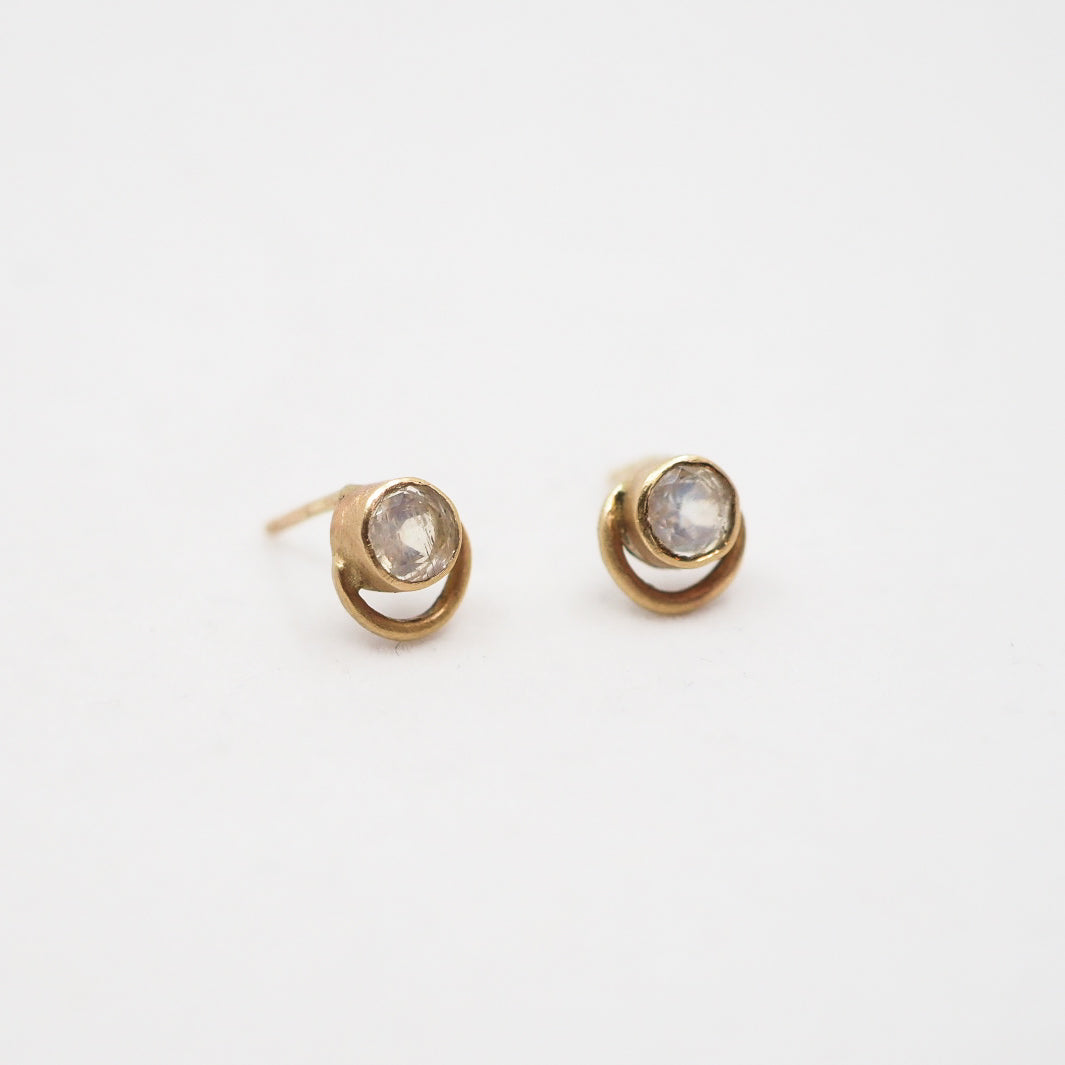 Pair of gold earrings with moonstone gemstones on a white background