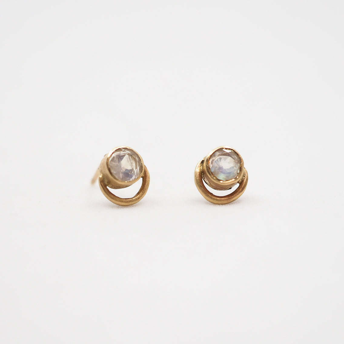 Pair of gold earrings with moonstones on a white background