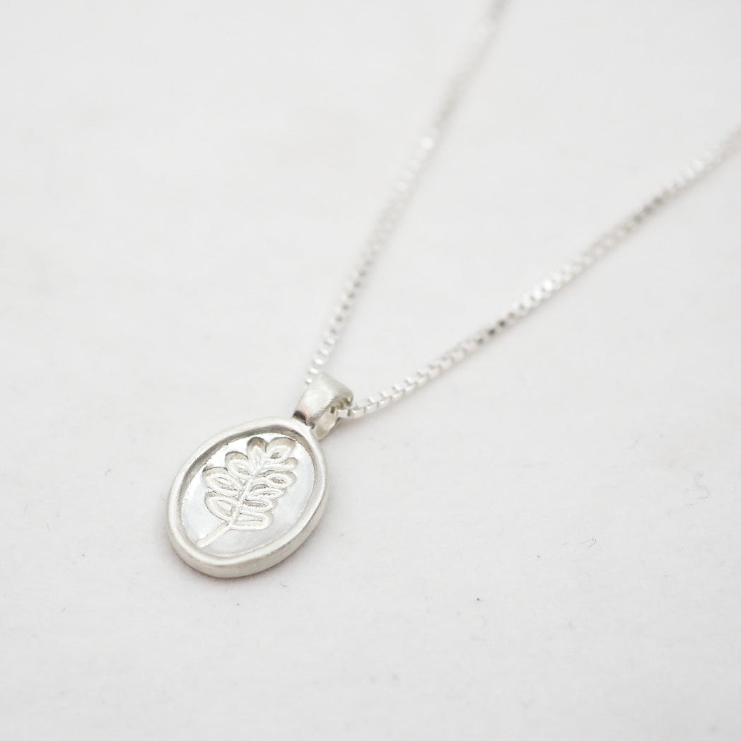 Silver necklace with a lupine pendant on a white background