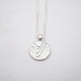 Silver pendant necklace on a light gray background