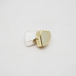 Gold and silver heart-shaped pendants on a light gray background