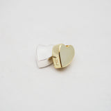 Gold and silver heart-shaped pendants on a light gray background