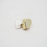 Gold and silver heart-shaped pendants on a light gray background