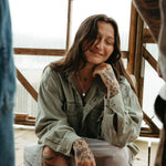 Woman with tattoos sitting on a chair indoors