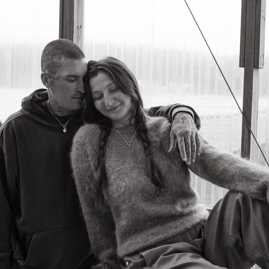 Black and white photo of a couple sitting close together indoors.