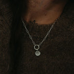 Silver necklace with a pendant on a dark background