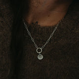 Silver necklace with a pendant on a dark background