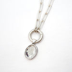 Silver necklace with a pendant on a white background