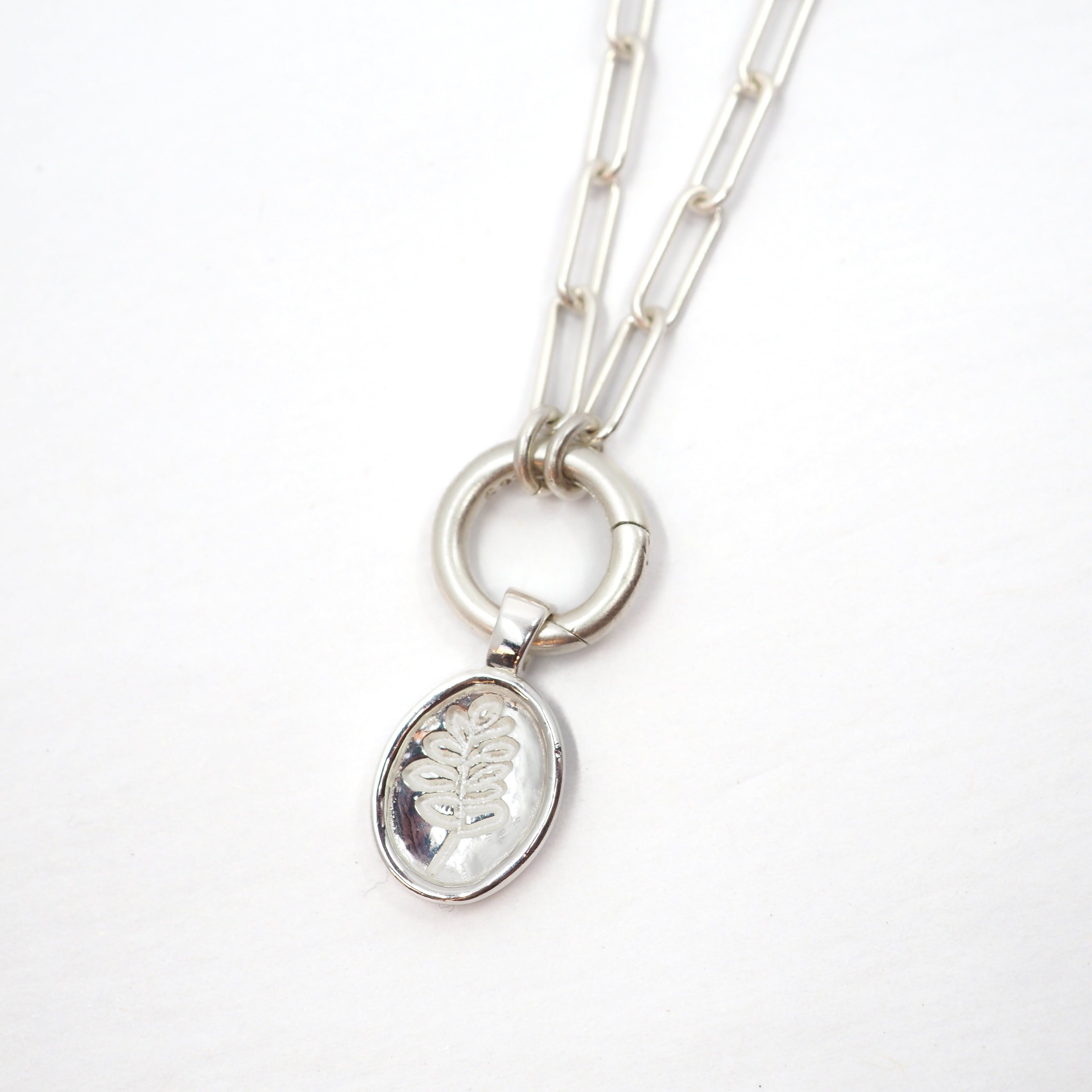 Silver necklace with a pendant on a white background