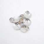 A cluster of hammered silver disc with the letter F charms with attached jump rings, displayed on a clean white background.