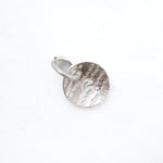 A small silver circular disc charm with a textured, hammered surface and a small attached metal loop, shown on a plain white background.