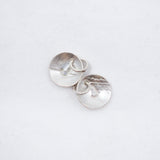 A pair of silver oval stud earrings with a hammered texture, displayed on a clean white background.