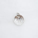 A small hammered silver pendant charm with a textured, organic surface and a top loop, shown on a plain white background.