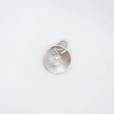A sterling silver round disc pendant with a brushed finish, featuring a cut-out letter 'R' and a small jump ring at the top, shown on a clean white background.