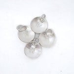 Four textured silver disc charms, each engraved with a letter 'W' and featuring a small jump ring, arranged on a plain white background.