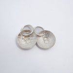 Five silver disc charms, each engraved with the letter A, arranged on a plain white background.