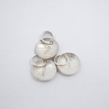 Three textured silver disc charms with attached jump rings, displayed on a clean white background.