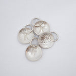 A pair of silver oval stud earrings with a hammered texture, displayed on a clean white background.