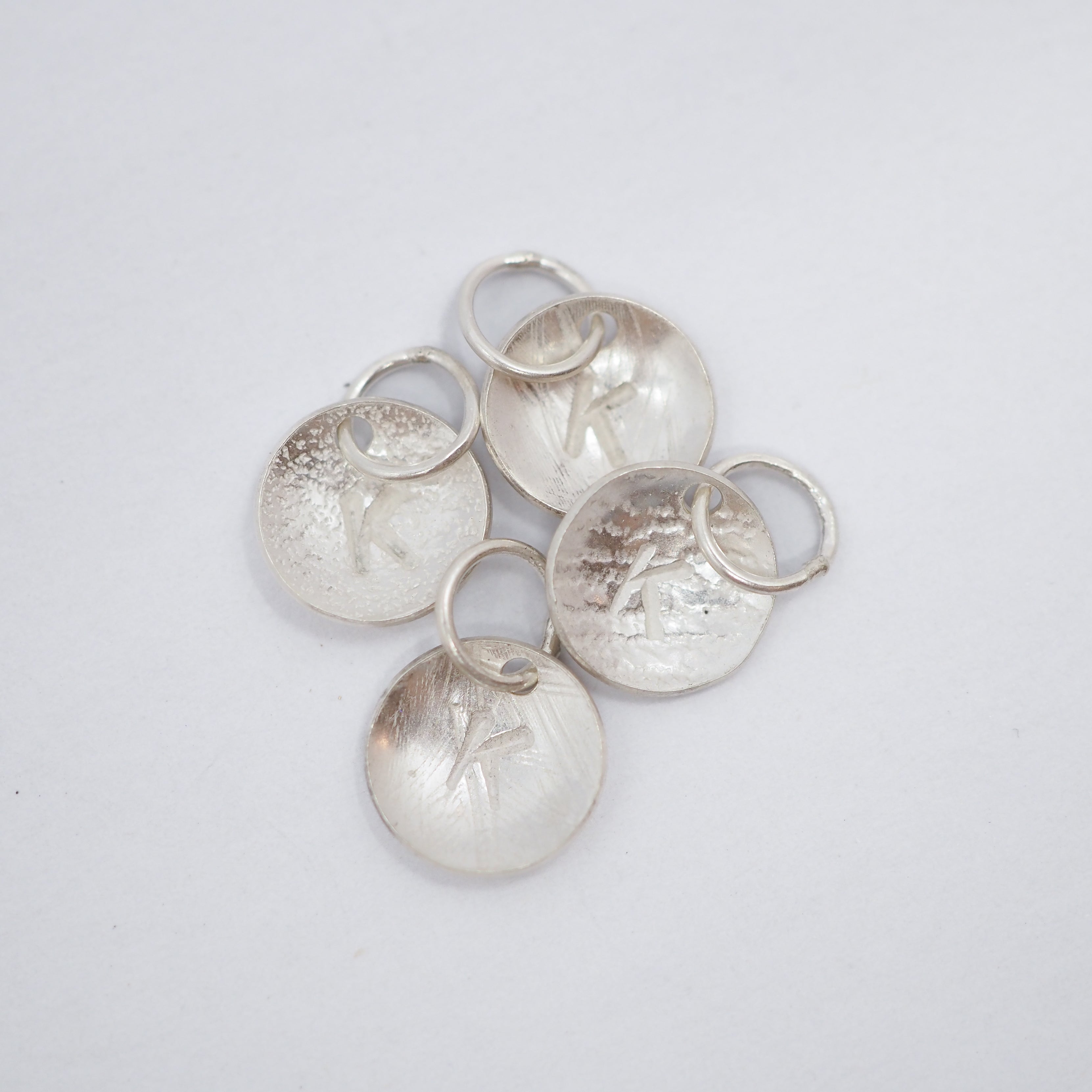 A pair of silver oval stud earrings with a hammered texture, displayed on a clean white background.