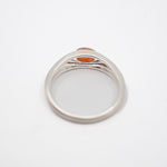 A silver-toned signet ring with a small oval orange stone, photographed from above on a plain white background.