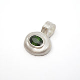A sterling silver pendant with a textured, organic-shaped bezel setting holding a dark green oval gemstone, shown on a plain white background.