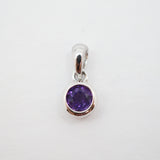 A sterling silver pendant charm featuring a round-cut purple gemstone in a bezel setting, shown on a plain white background.