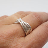 Silver ring on a person's finger against a plain background