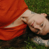 Person wearing an orange dress lying on grass